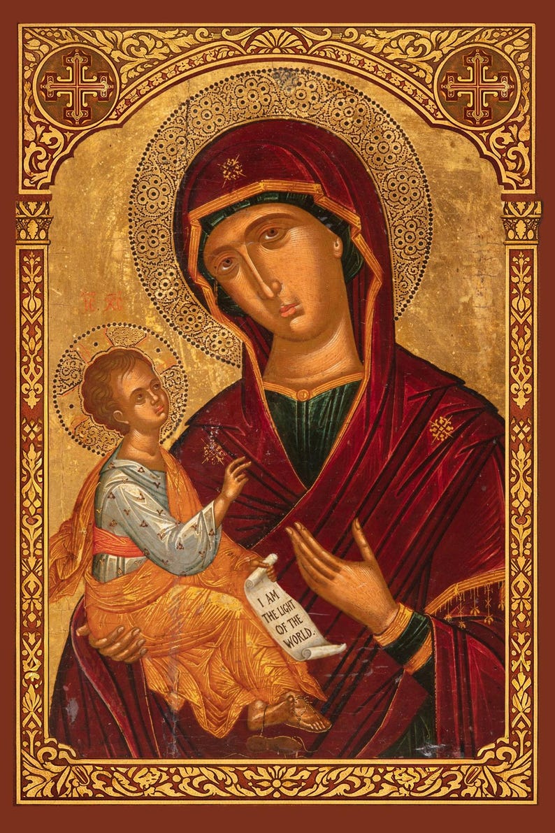 Puede incluir: Un icono religioso pintado que muestra una figura con t&uacute;nica roja oscura sosteniendo a un ni&ntilde;o con ropa clara. El ni&ntilde;o sostiene un pergamino con el texto I AM THE LIGHT OF THE WORLD. El fondo es dorado con bordes decorativos.