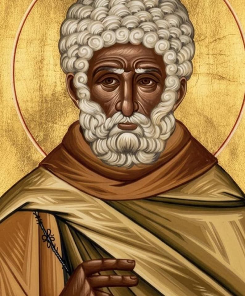 Puede incluir: Icono de un hombre con piel oscura, barba rizada blanca y cabello rizado blanco. Viste una t&uacute;nica marr&oacute;n y sostiene un objeto delgado y negro. El fondo es dorado con un halo rojo.