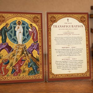 Puede incluir: Una tarjeta religiosa de doble cara que presenta un icono de la Transfiguración de Jesús en un lado y el texto The Holy Transfiguration of Our Lord Jesus Christ con oraciones en el otro, enmarcado por un borde decorativo dorado y rojo.