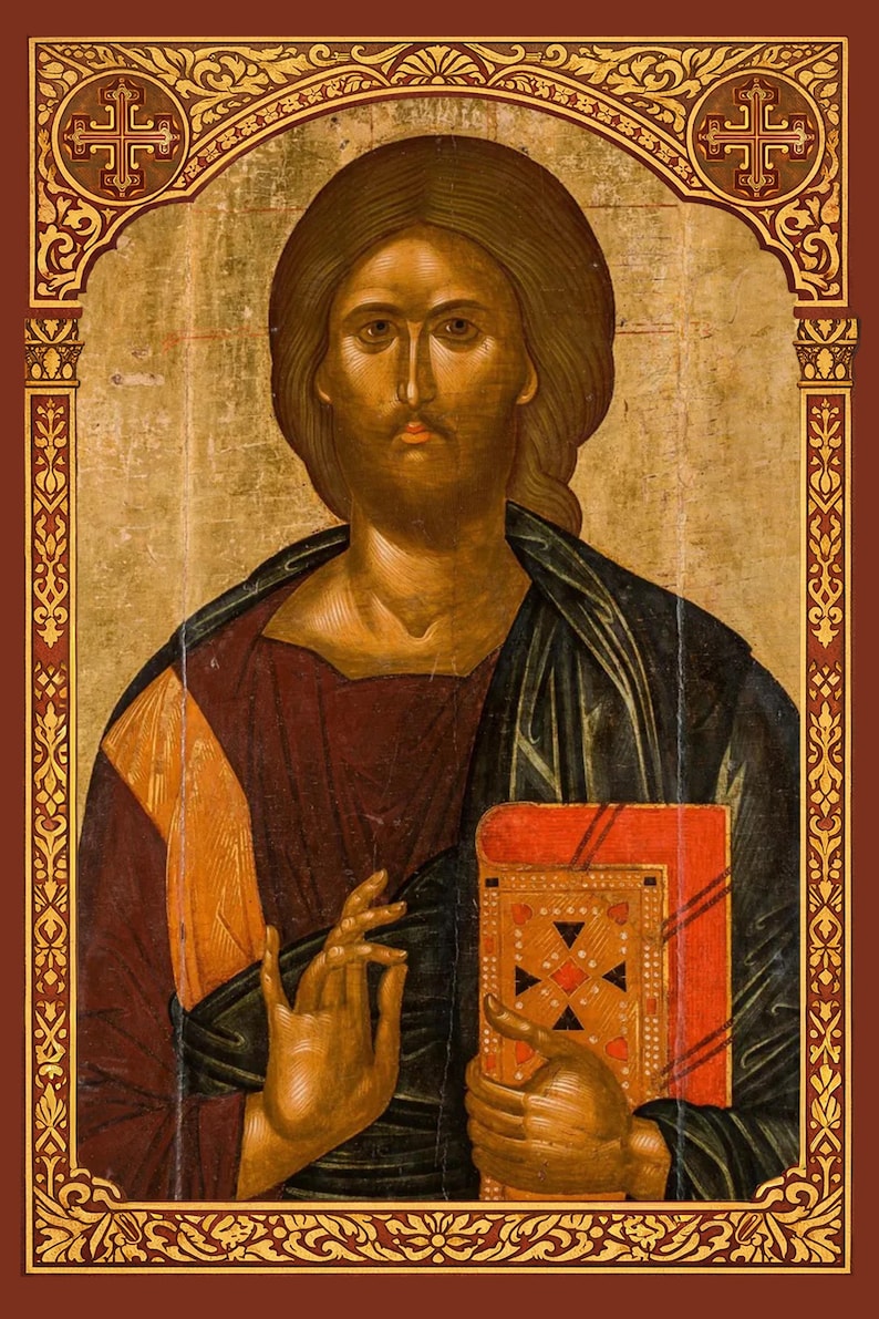 Puede incluir: Un icono religioso que muestra una figura central con cabello largo casta&ntilde;o y barba, vistiendo una capa azul oscuro sobre una t&uacute;nica granate. La figura sostiene un libro rojo con detalles dorados y hace un gesto con la mano. El borde es dorado.