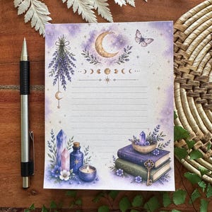 May include: A rectangular sheet of lined stationery featuring a purple watercolor background with illustrations of a crescent moon, a butterfly, lavender sprigs, crystals, a blue bottle, a candle, and a stack of two books with a metal key.