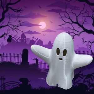 May include: A white, three-dimensional ghost figurine with a smooth, rounded head and outstretched arms. The ghost features two oval-shaped black eyes and a small, circular black mouth, creating a simple, recognisable spectral character.