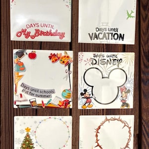 May include: A collection of six white square countdown signs with various themes. The signs include text like "Days Until My Birthday," "Vacation," "Schools out for summer," "Disney," "Christmas," and "Jesus Birthday."