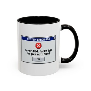 May include: White ceramic mug with a black interior and handle. The mug features a graphic of a system error message with the text "SYSTEM ERROR 404" and "Error 404: fucks left to give not found."