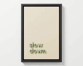 „Slow Down“ 3D-Wandbild, erhabene Schrift in Salbeigrün, gerahmte Typografie auf cremefarbenem Stoff
