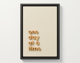 „Ein Tag nach dem anderen“ – 3D-Wandbild, ockerfarbene Reliefschrift, gerahmte Typografie auf cremefarbenem Stoff