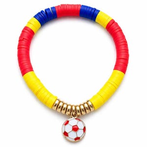 May include: A colorful bracelet featuring red, yellow, and blue disc beads. The bracelet has a gold-toned charm of a soccer ball with red and white details. The bracelet is on a white background.
