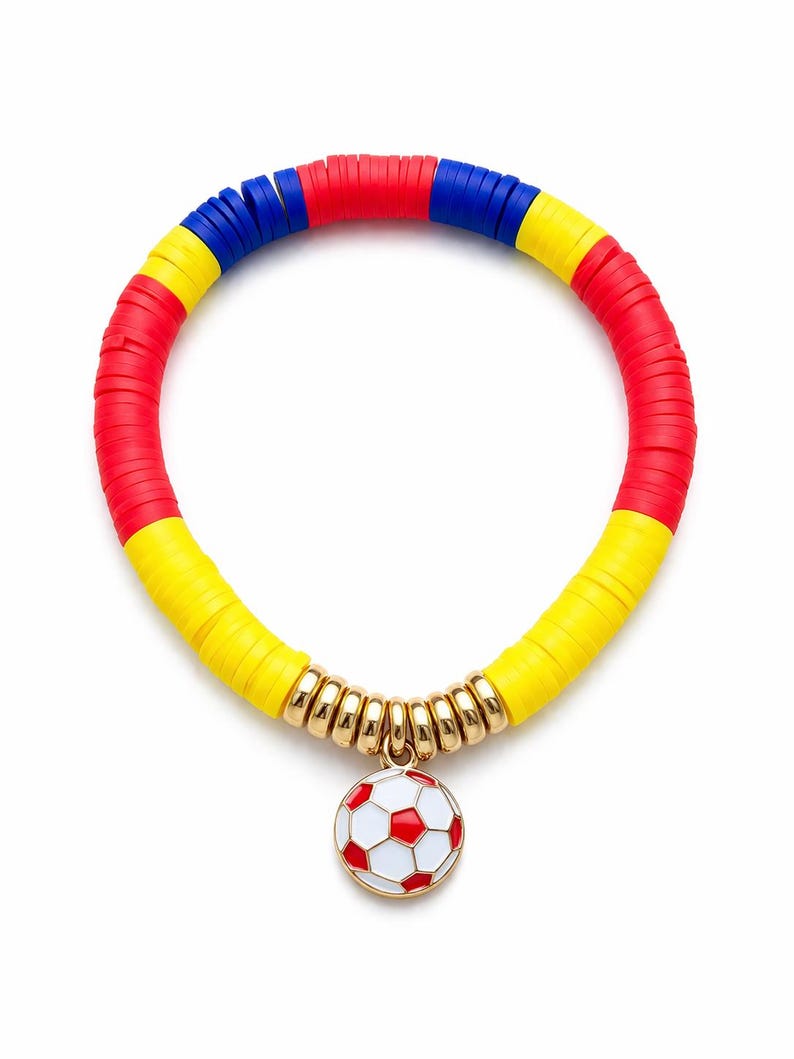 May include: A colorful bracelet featuring red, yellow, and blue disc beads. The bracelet has a gold-toned charm of a soccer ball with red and white details. The bracelet is on a white background.