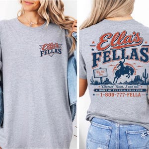 The image is a collage of two photos. In the first photo, a woman is wearing a grey t-shirt with the text "Ellas Fellas" printed on it. In the second photo, the back of the same t-shirt is shown, featuring a graphic design with a cowboy, a sign, and the text "Ellas Fellas" prominently displayed.