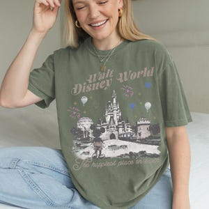 A smiling woman wearing a green t-shirt with a Disney World graphic and text.
