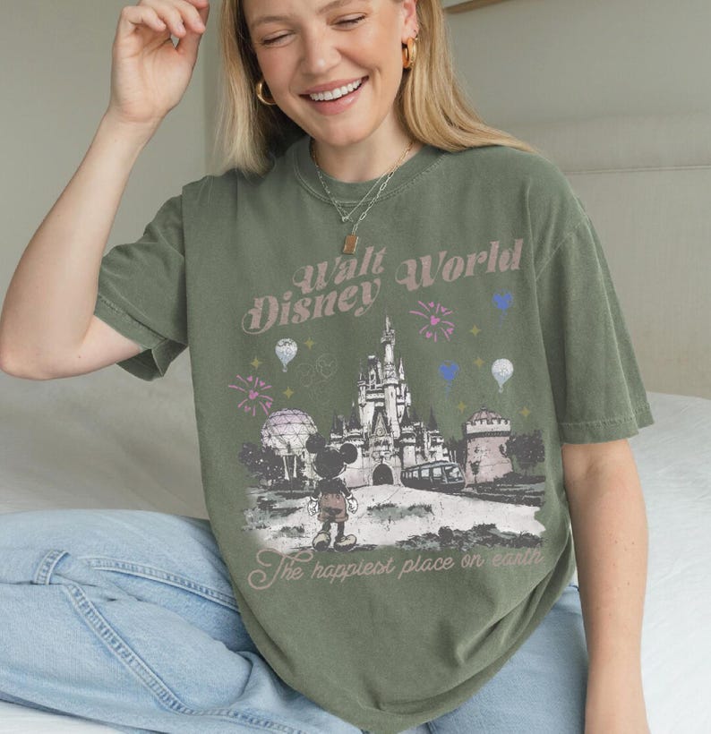 A smiling woman wearing a green t-shirt with a Disney World graphic and text.