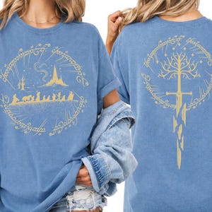 two women wearing blue t-shirts with gold designs on the back.