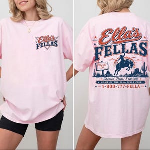 A woman wearing a pink t-shirt with a graphic design on the back.