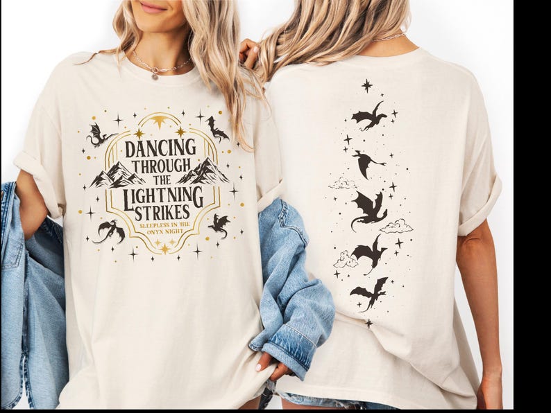 two women wearing white t-shirts with a graphic design on the front and back.