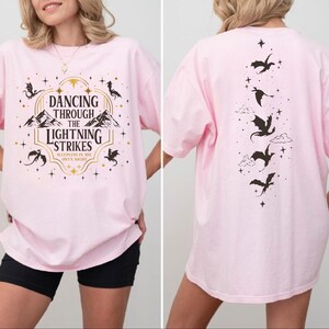 A woman wearing a pink t-shirt with a graphic design on the front and back.