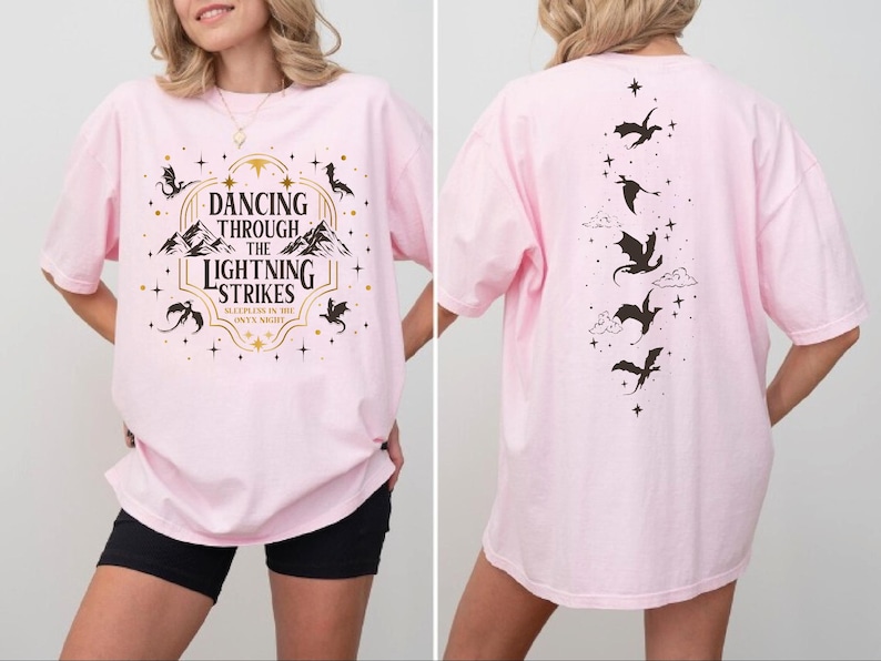 A woman wearing a pink t-shirt with a graphic design on the front and back.