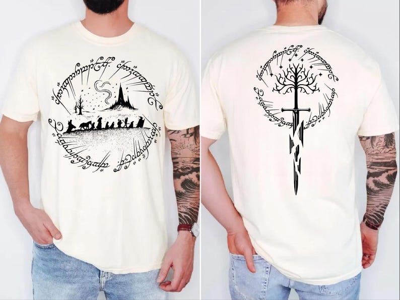 a man wearing a white t-shirt with a graphic design featuring a castle, a tree, and a sword. The design is circular and includes text and symbols.