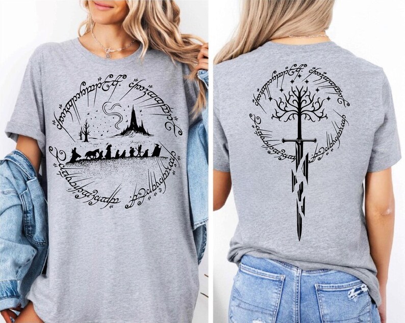 The image is a collage of two photos showing the back and front of a gray t-shirt with a graphic design featuring a castle, a tree, and a sword.