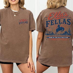 A woman wearing a brown t-shirt with a graphic design on the back.