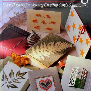 May include: A book titled "Card Crafting: Over 45 Ideas for Making Greeting Cards & Stationery" by Gillian Souter. The cover features various handmade greeting cards with different designs, including a fern, a heart, and stars.