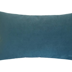 May include: A rectangular teal-colored pillow with a soft, velvety texture. The pillow is a solid color and appears to be made of a plush fabric. This decorative pillow is suitable for a bed or sofa.
