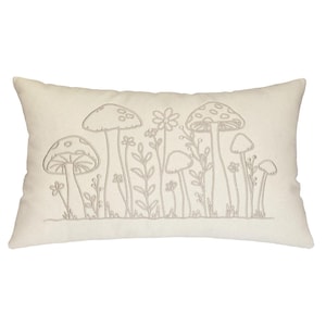 May include: Cream-colored rectangular pillow featuring an embroidered design of mushrooms and flowers. The design is in a neutral, light brown color, creating a subtle contrast against the pillow's background. The pillow is a decorative item.