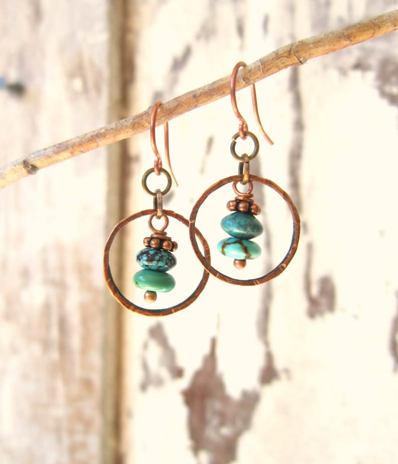 May include: Copper hoop earrings with turquoise gemstone beads. The hoops are hammered and have a rustic look.