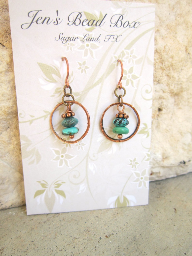 May include: Copper hoop earrings with turquoise and copper beads. The earrings are on a white card with the text "Jen's Bead Box Sugar Land, TX".