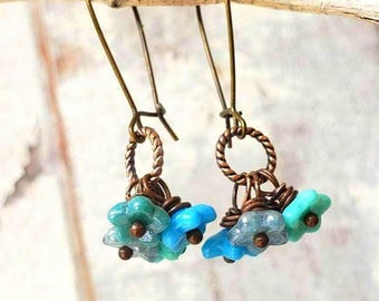 Brincos de flor em vidro checo azul. Brincos de vidro e cobre. Brincos pendentes com arranjo de flores. Brincos em formato de cacho. Brincos multicoloridos em azul.