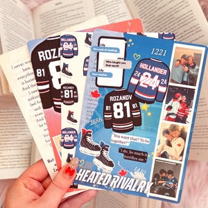 Op de afbeelding: Een verzameling decoratieve kaarten met hockeytrui-ontwerpen met de namen "Rozanov" en "Hollander" en de nummers "81" en "24". De kaarten bevatten tekstballonnen met citaten en een telefoonbeeldschermgrafiek. De zin "Heated Rivalry" is ook zichtbaar.