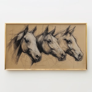 Puede incluir: Una obra de arte enmarcada que presenta un boceto a carboncillo de tres cabezas de caballo. Los caballos están representados de perfil, con sombreado y líneas detalladas. La obra está enmarcada en un marco dorado y montada sobre un fondo beige.