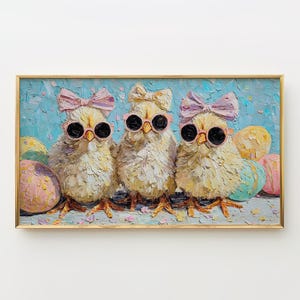 May include: A framed oil painting featuring three fluffy yellow chicks wearing sunglasses and pink bows. The chicks are surrounded by colorful Easter eggs against a textured blue background. The artwork is in a gold frame.