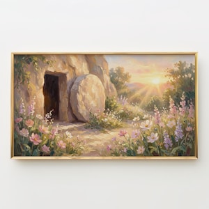 May include: A framed painting depicts an open tomb with a large stone rolled away. The scene is bathed in warm sunlight, with a vibrant sunrise in the background. Pink and white flowers bloom in the foreground, creating a serene and hopeful atmosphere.