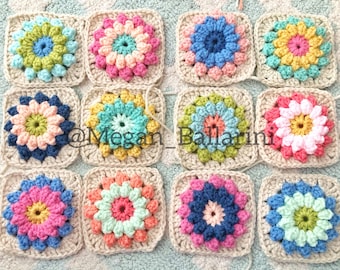 Puede incluir: Nueve cuadrados de ganchillo con un diseño de flor colorido en el centro de cada cuadrado. Los cuadrados están dispuestos en tres filas de tres. Los cuadrados están hechos con una variedad de colores, incluyendo rosa, azul, verde, amarillo y blanco.