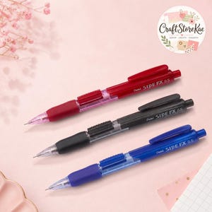May include: Three Pentel SIDE FX 0.5 mechanical pencils in red, black, and blue. Each pencil features a side-click advance mechanism, a pocket clip, a transparent barrel section, and a conical tip. The brand name and model are printed on the barrel.