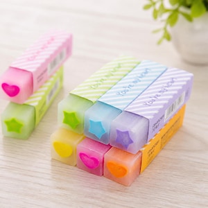 Peut inclure: Une collection de gommes rectangulaires aux couleurs pastel, chacune dotée d'un insert en forme d'étoile ou de cœur à l'extrémité. Les gommes sont enveloppées dans des manchons en papier rayés avec le texte "You're my heart" imprimé dessus.