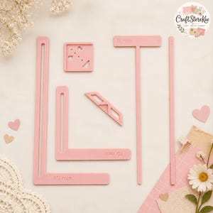 Puede incluir: Un conjunto de plantillas de manualidades de plástico rosa claro que incluye una regla en forma de L con marcas de 15 mm, una regla en forma de T con marcas de 5 mm, una pequeña guía cuadrada con recortes, una tira recta fina y un refuerzo diagonal.