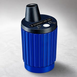 May include: A blue Staedtler 502 lead pointer sharpener with a cylindrical, ribbed body and a black top section. The top features a circular opening, a white circular insert, and printed text that reads STAEDTLER 502 with two small icons.