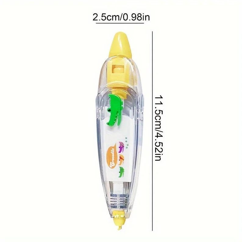 Puede incluir: Un dispensador de cinta correctora transparente y amarillo con un dise&ntilde;o de cocodrilo verde. El dispensador mide 11,5 cm de largo y 2,5 cm de ancho. El dispensador tiene la palabra "Crocodile" impresa.