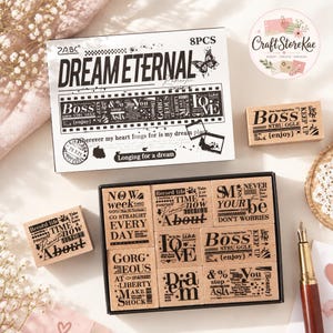 May include: A set of eight wooden rubber stamps featuring various typographic designs and phrases like Dream Eternal, Boss, and Record Life. The set includes a white cardboard box with black text and graphics, and individual wooden blocks with black ink designs.