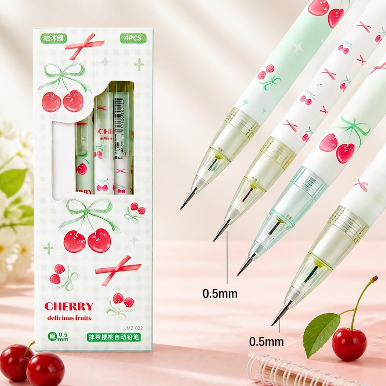 May include: A set of four mechanical pencils with a light green barrel featuring a red cherry and ribbon pattern. The packaging box displays the text CHERRY delicious fruits and 0.5 mm, with a clear window showing the pencils inside the box.