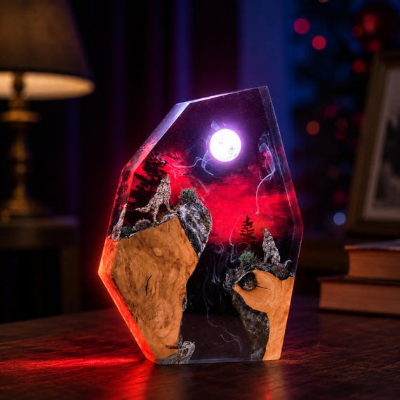 A hand-poured resin diorama nightlight with a howling wolf silhouetted against a glowing red moon — the kind of moody, atmospheric art piece that looks like it escaped from a fantasy novel.