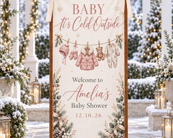 May include: A vertical banner on a wooden stand featuring the text BABY it's Cold Outside, Welcome to Amelia's Baby Shower, and 12.10.26. The design includes illustrations of a pink winter coat, hat, mittens, teddy bear, and baby onesie.