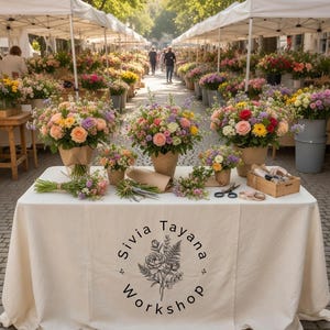 May include: A flower market stall displays bouquets of colorful flowers in paper wrapping. The table is covered with a cream-colored tablecloth with the text "Sivia Tayana Workshop" printed on it. Scissors and other florist tools are visible.