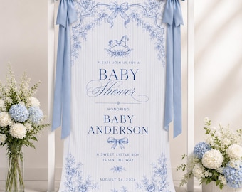 May include: A vertical baby shower banner featuring a blue and white toile-inspired floral pattern, a rocking horse illustration, and two large blue satin bows at the top. The text reads: Please join us for a baby shower honoring Baby Anderson.