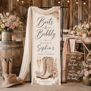 May include: A vertical banner featuring the text Boots & Bubbly, Welcome to Sophia's Bridal Shower, and the date 10.05.2026. The design includes illustrations of a champagne flute, a pair of floral cowboy boots, and pink floral accents.