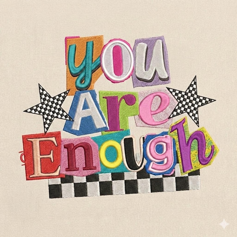 May include: Embroidered design with the words "YOU ARE ENOUGH" in colorful, cut-out style letters. The design includes two checkered star accents and a checkered border at the bottom, all on a cream-colored background.