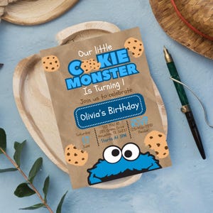 May include: A rectangular birthday invitation printed on brown paper featuring blue text that reads Our little COOKIE MONSTER Is Turning 1, Olivia's Birthday, and event details. The design includes illustrations of chocolate chip cookies.