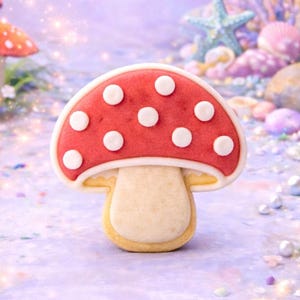 Op de afbeelding: Een rode en witte paddenstoelkoekjessnijder met de tekst "toadstool cookie cutter" en "STL digital download". De koekjessnijder heeft de vorm van een paddenstoel met witte stippen op de rode kap. De achtergrond heeft andere paddenstoel illustraties.