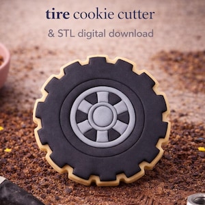 May include: A tire-shaped cookie cutter with a black tire design and a light grey wheel centre. The text "tire cookie cutter & STL digital download" is visible. The cookie is on a brown surface with a piping bag and nut.